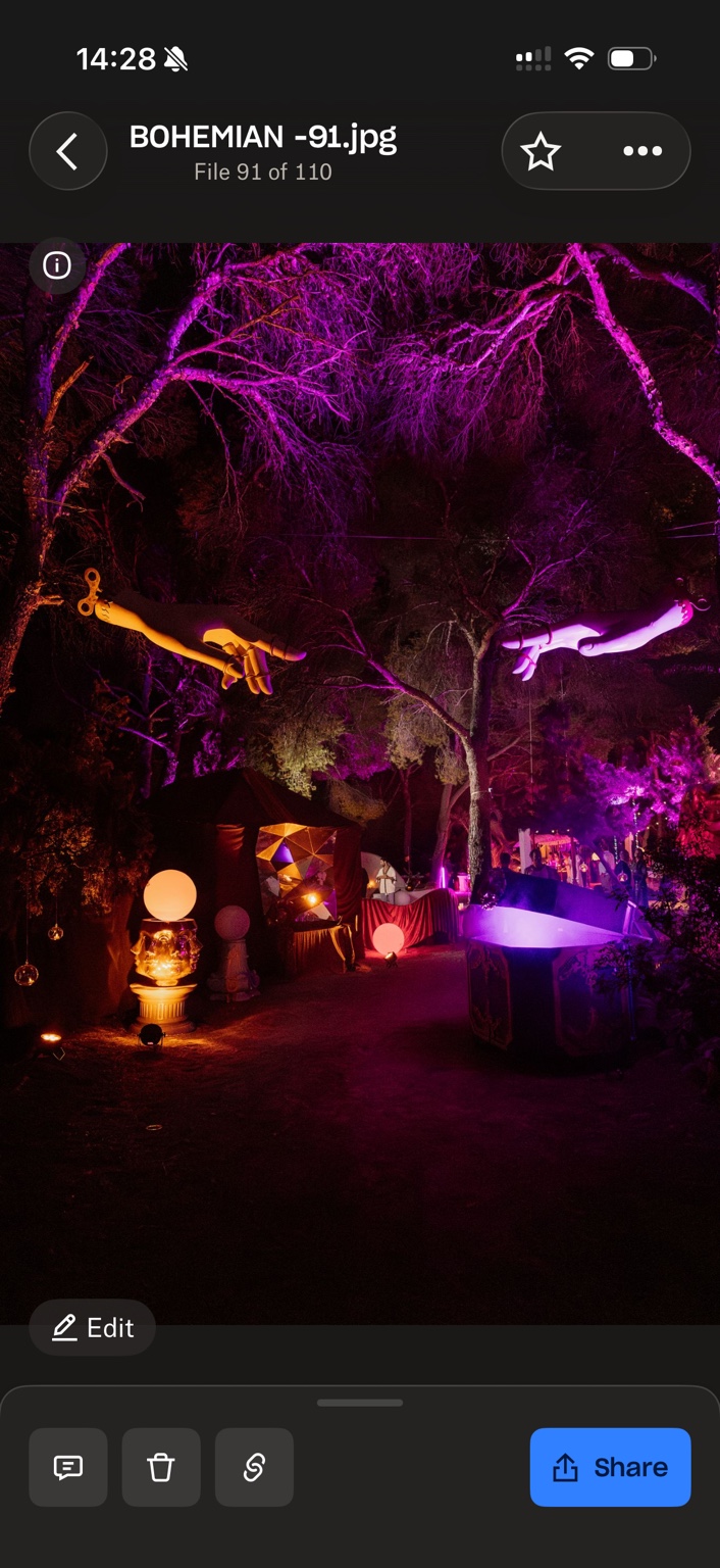 Purple illuminated woodland with suspended sculptural hands and immersive event installations
